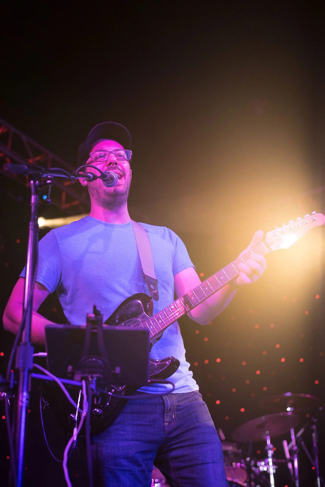 Guitar and vocals under purple and orange lights